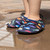 Baby wearing Multi Sharks Aqua Shoes in Black, standing on the water puddle