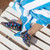 Baby boy wearing Multi Sharks Aqua Shoes in Black, laying on beach towel