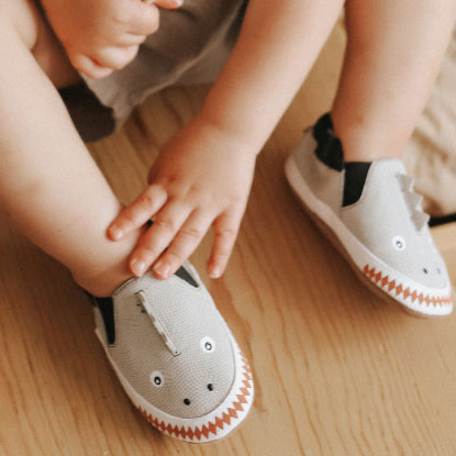 baby wearing shark shoes