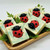 Artisan Ladybug Soap, with a red and black toy ladybug embed in green and cream swirled bars — displayed on a wooden tray with leaf accents for bath time fun.