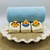 Surf’s Up Duckling handmade soaps displayed on a large shell dish with rolled blue towel — fun rubber duck toys in beach outfits, olive oil and shea butter soap.