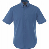 A short sleeve button-up shirt in blue with a chest pocket and a logo on the label.