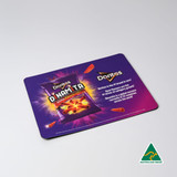 A mouse mat featuring a vibrant design with purple and orange colours, showcasing a snack bag and an Australian made emblem.