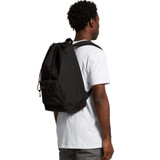 A black recycled rucksack is worn on the back of a person, featuring a simple design with adjustable straps.