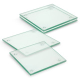 A set of four square glass coasters with a clear finish, featuring rounded edges and rubber grips at the corners.