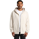 A man wearing a cream heavy zip hoodie with a front pocket and a hood, featuring a logo.