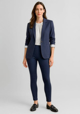 A woman wearing a navy blazer and high-rise navy leggings, styled with a white blouse and loafers.