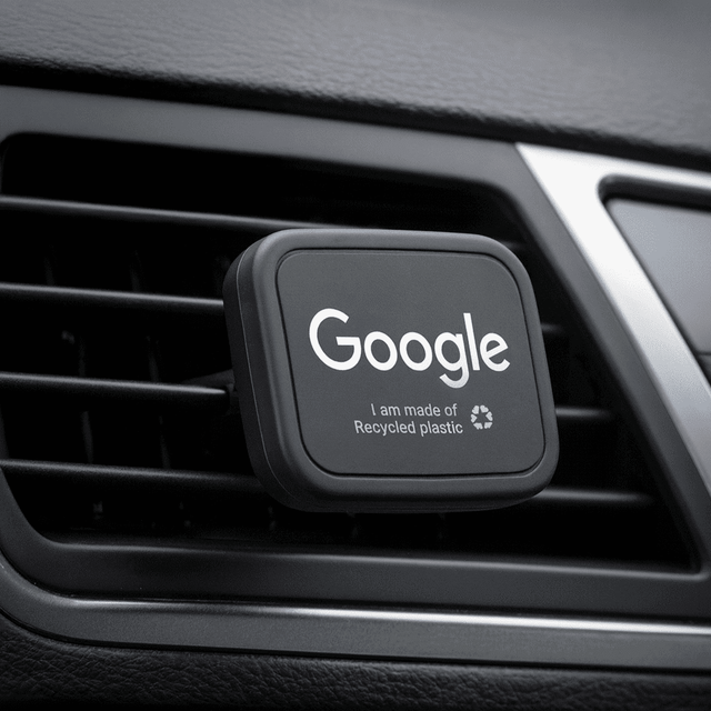 A rectangular black car vent mount featuring a logo, made from recycled plastic.