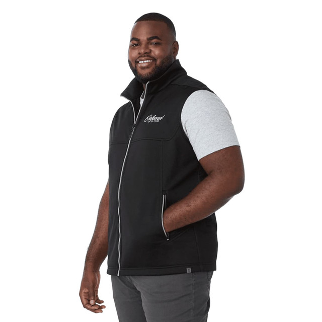 A black eco waterproof softshell vest with a zip front, featuring a logo, worn by a smiling man.