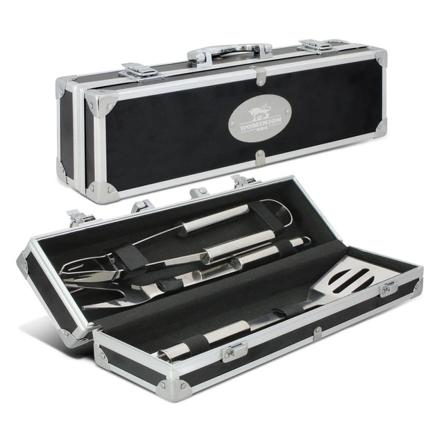 A black and silver BBQ tool set in a metal case, featuring a spatula, tongs, and a fork.