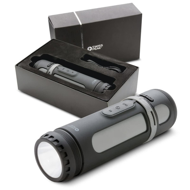 A Swiss Peak 4-in-1 speaker in black, displayed with its box and charging cable, featuring various buttons on the device.