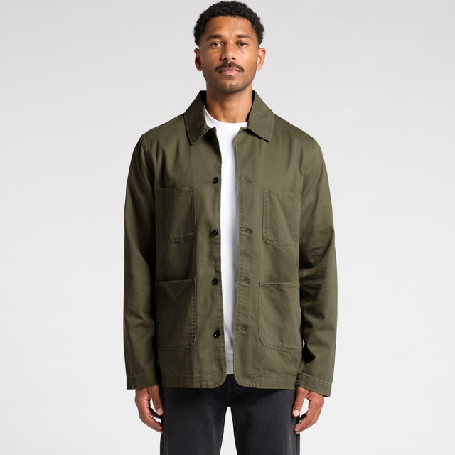 An olive green chore jacket with multiple pockets, featuring a collared neckline and button-up front. It has a logo.
