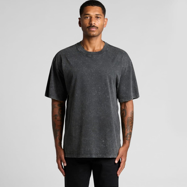 A man wearing a stone wash heavy tee in dark grey, featuring a relaxed fit and short sleeves.
