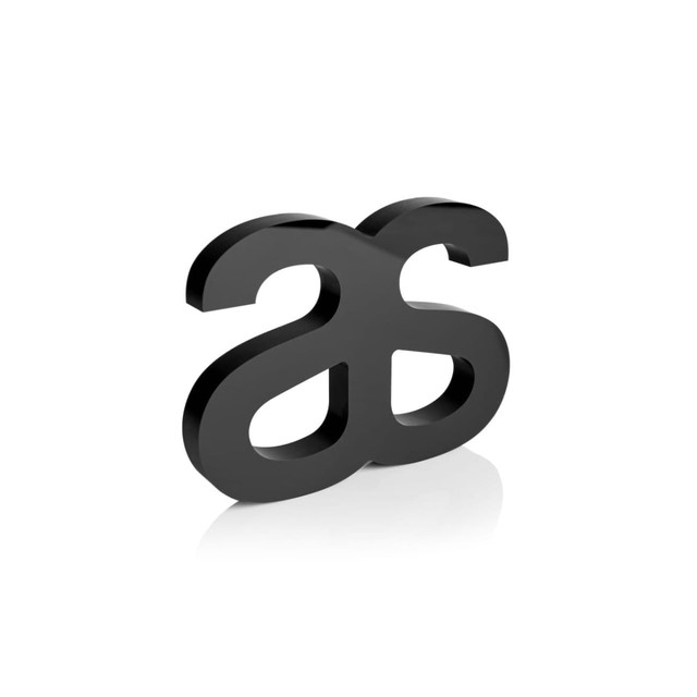 A black plaque with a stylised two-letter logo, featuring smooth, curved edges and a reflective surface.