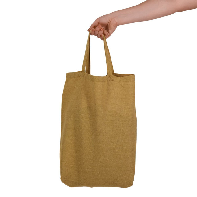 A short-handled, mustard yellow tote bag being held by a hand. The bag features an unembellished design and has a logo.