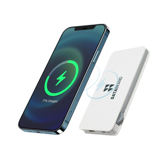 A white wireless power bank next to a smartphone displaying a charging indicator. The power bank features a logo.