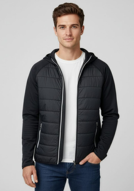A man wearing a black puffer jacket with a hood, paired with a white t-shirt and blue jeans. The jacket has a logo.