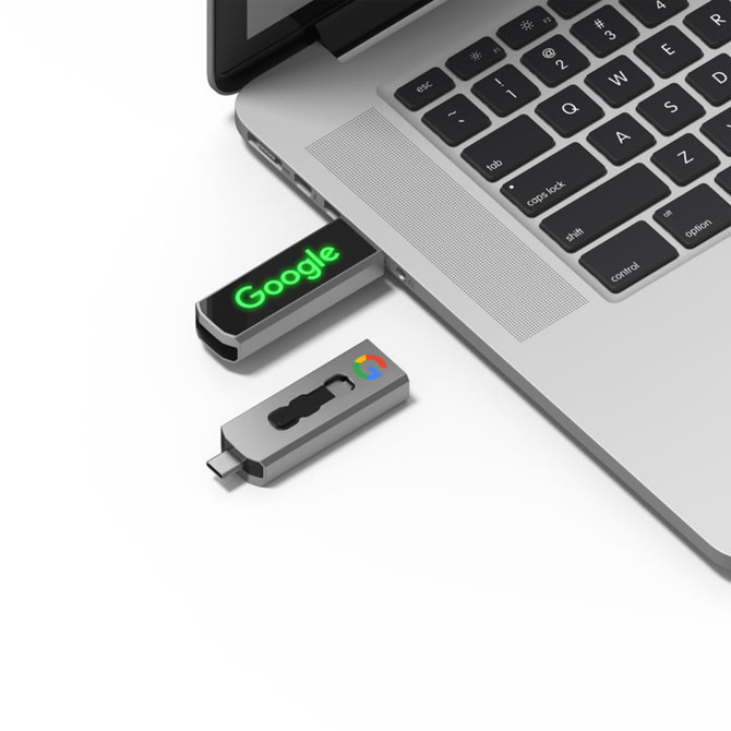 A USB flash drive in black and grey connecting to a laptop, featuring a logo and LED lights.