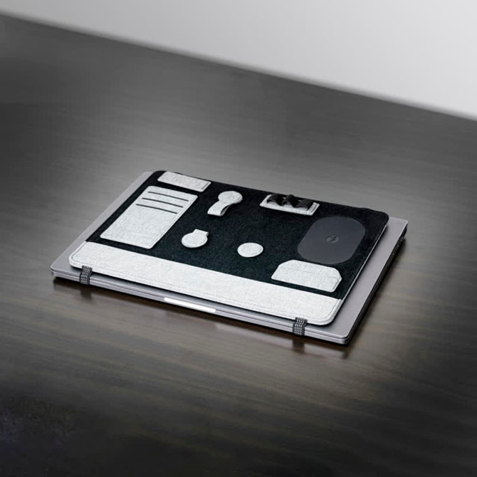 A grey and black laptop organiser featuring various compartments and a logo, resting on a dark surface.