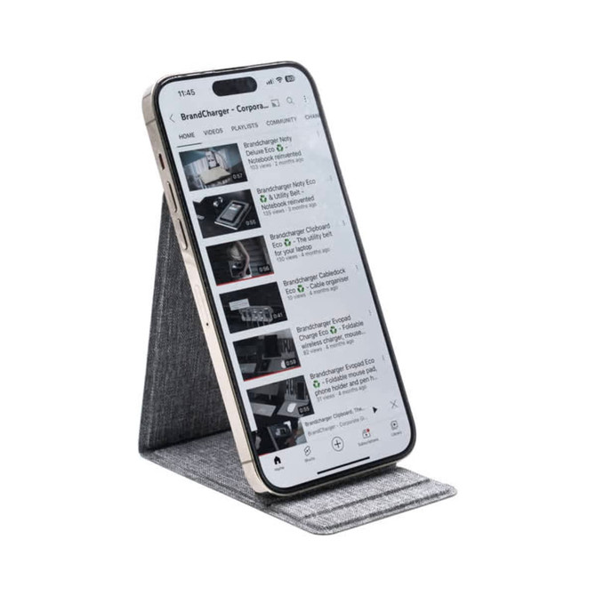 A smartphone on a grey wireless charger stand, displaying a video streaming interface. The stand has a sleek design.