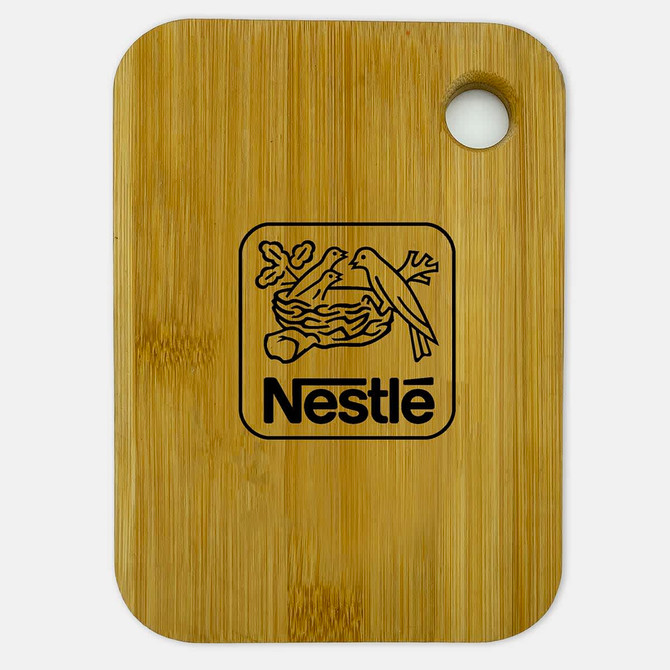 A small bamboo cutting board featuring a circular hole and a logo. The board has a natural wood finish.