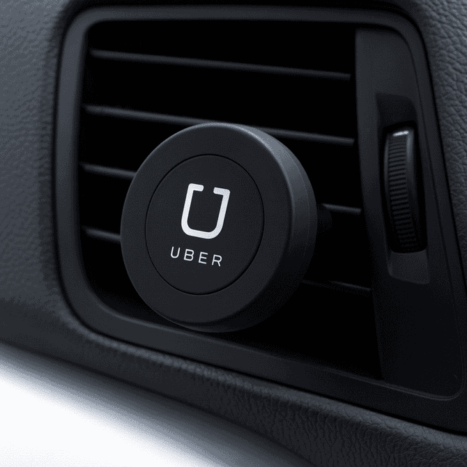 A round, black magnetic car vent mount, designed for holding phones, attached to a vehicle vent.