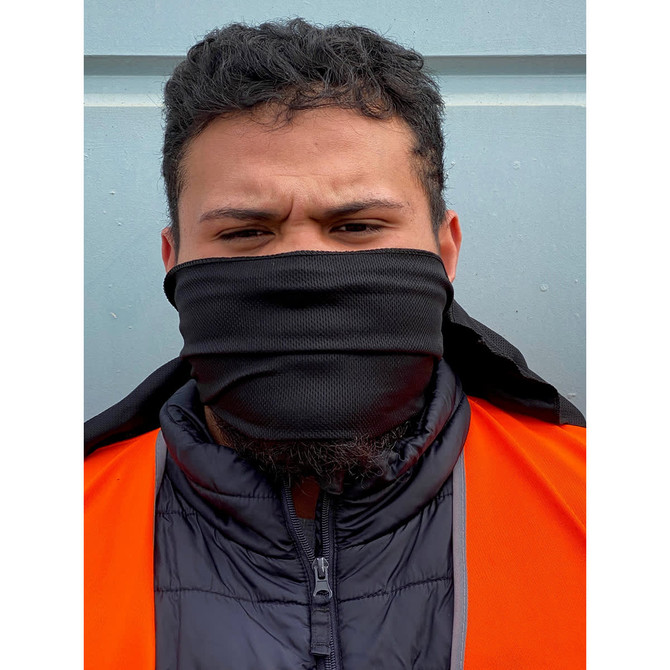 A black cooling towel is worn as a face covering by a person in an orange vest, standing against a blue background.