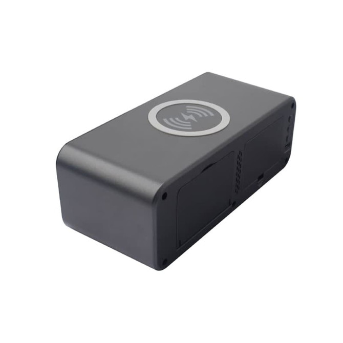 A black wireless charging speaker with a circular charging area on top and ventilation slots on the sides.