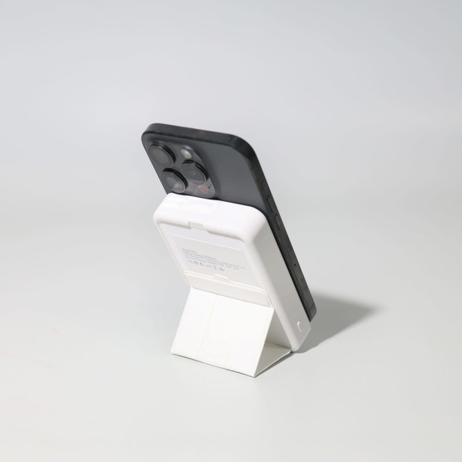 A black and white Turbo 5000mAh wireless charging power bank set on a stand, showcasing its sleek design.