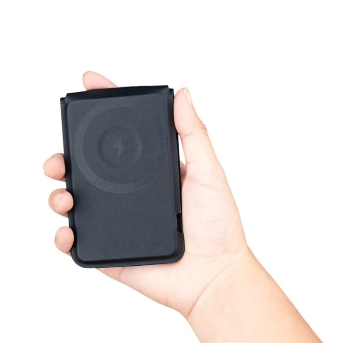 A black magnetic card wallet and wireless charging stand held in a hand. It features a logo on the surface.