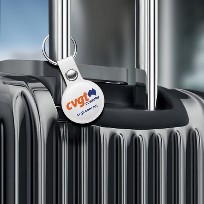 A black suitcase with a silver handle featuring a round tag with a logo.