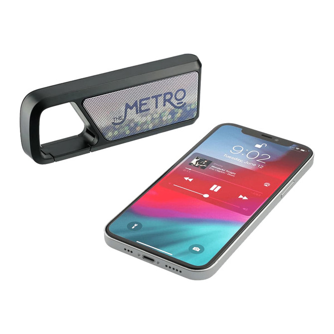 A Bluetooth speaker in black alongside a smartphone displaying a music app interface. The speaker has a logo.