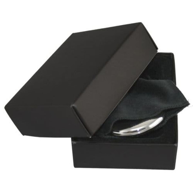 A silver compact mirror inside a black box, resting on a soft black cloth. The box has a minimalist design.