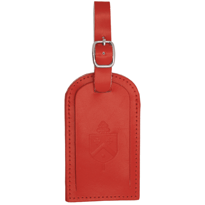 A red luggage tag featuring a decorative design and a buckle for attachment. It has a branded logo.