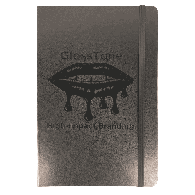 A black journal with an elastic band and a logo on the cover, featuring a glossy finish.