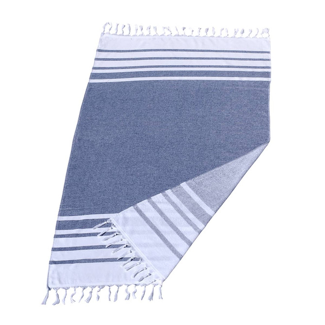 A Turkish beach towel featuring a navy blue and white design with striped patterns and fringed edges. It has branding.
