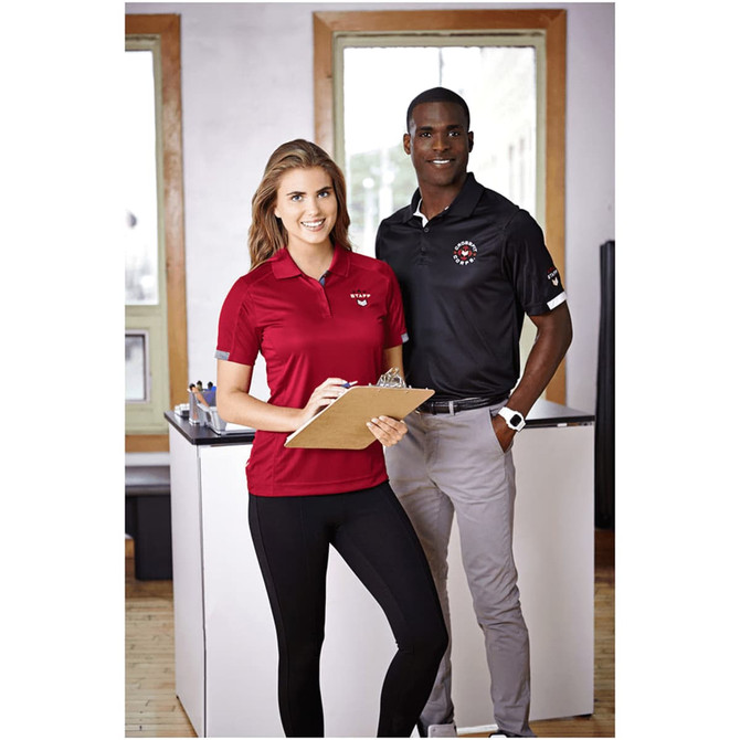 A red women's polo shirt with short sleeves displayed on a model, alongside a man in a black polo shirt, both smiling.