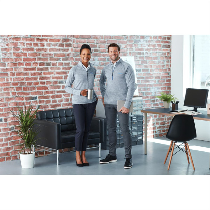 A grey knitted half zip jumper worn by two models, one holding a drink, posed in a modern office setting.
