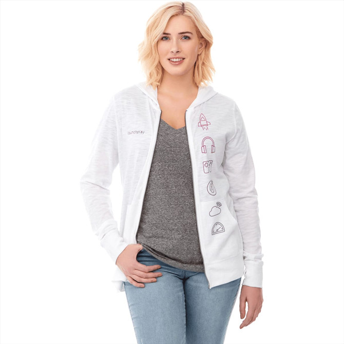 A woman wearing a white Garner Knit Full Zip Hoody, with a grey T-shirt and light blue jeans. The hoody features a logo.
