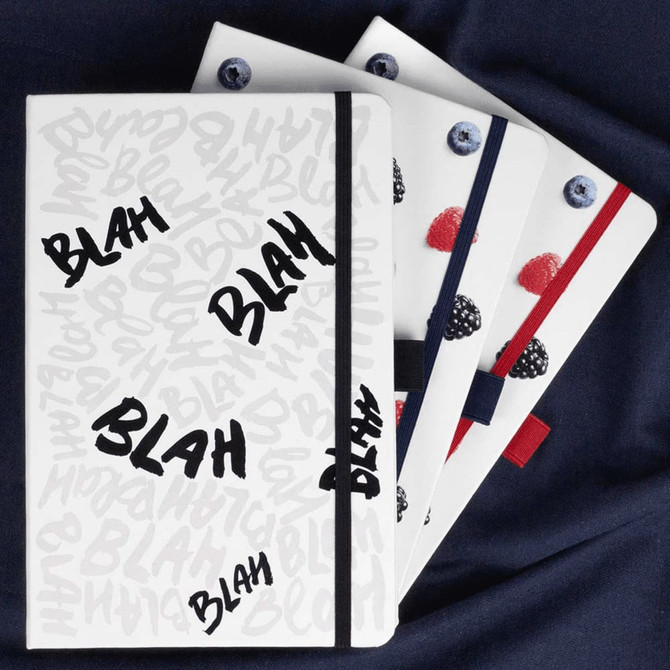 A set of three bound journals with colourful accents, featuring a white cover with playful text and a logo.