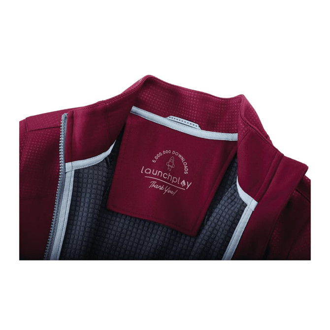 A maroon women's jacket with a full zip, featuring thumb holes and a lined interior. It has a logo on the inside.