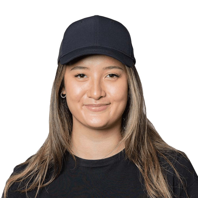 A navy Falcon Flex Cap displayed on a smiling woman with long, straight hair. The cap features a logo on the front.