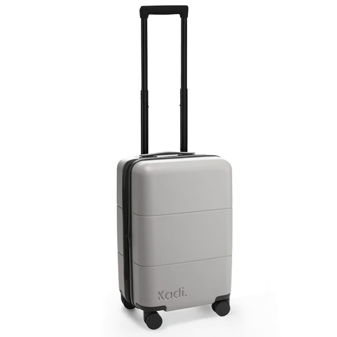 A grey carry-on suitcase with four wheels and a retractable handle, featuring branding on the side.