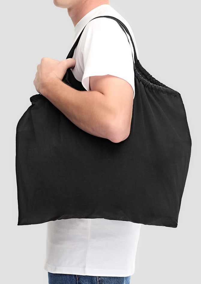 A black nylon tote bag is being carried by a person, featuring a simple design and a logo.