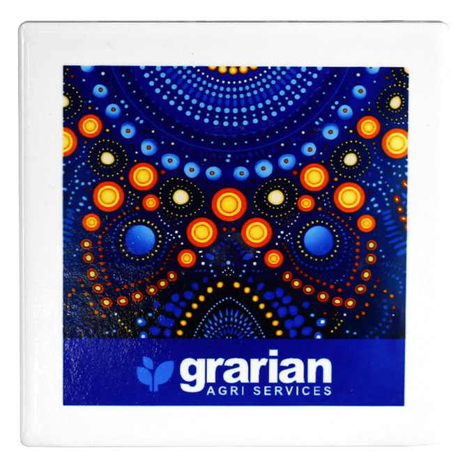 A square ceramic coaster featuring a vibrant blue design with orange and yellow dots, alongside branding.