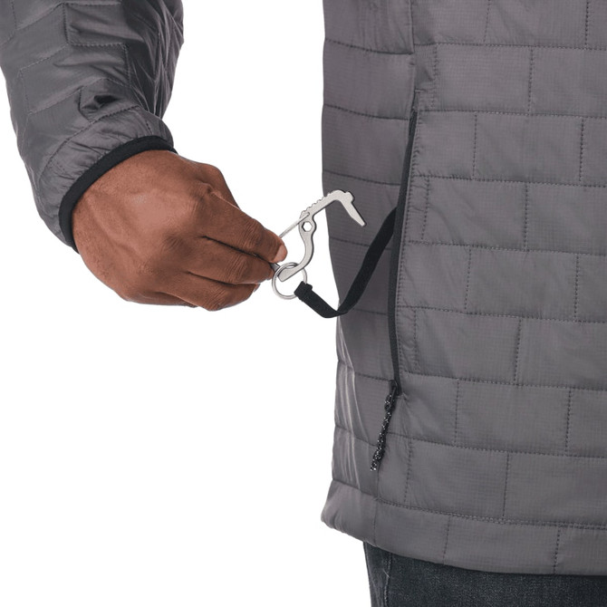A close-up of a man's hand holding a clip from a grey insulated puffer jacket. The jacket features a quilted design.