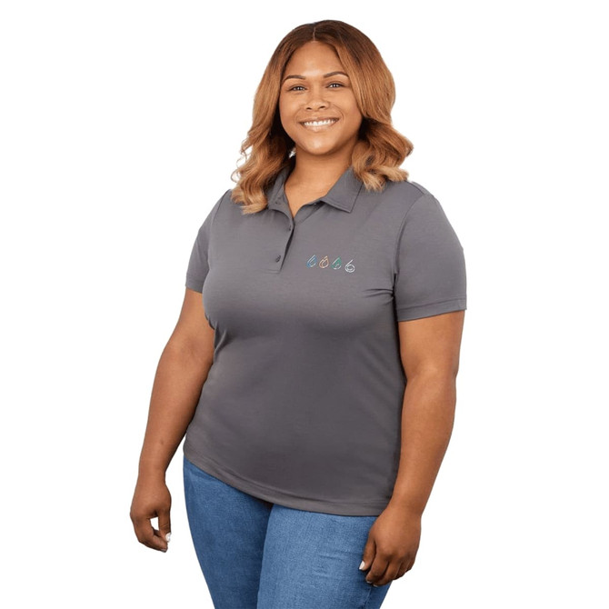 A woman wearing a grey polo shirt featuring a logo on the left side. The shirt is fitted and has a classic collar.