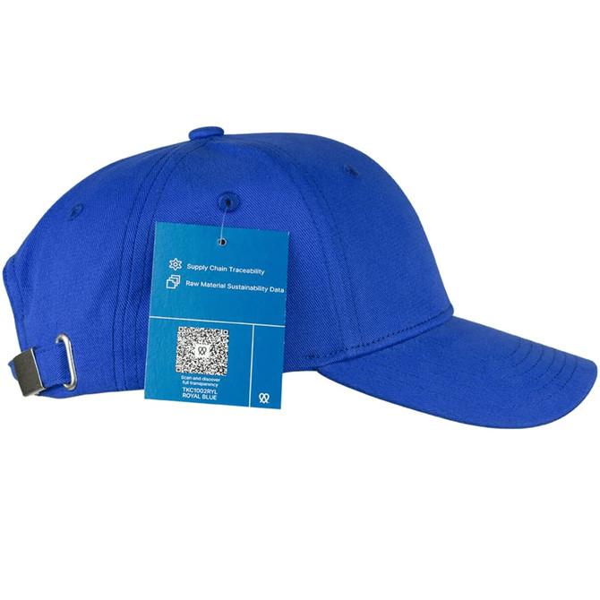 A blue organic cotton twill cap with an adjustable strap and a tag detailing material sustainability.