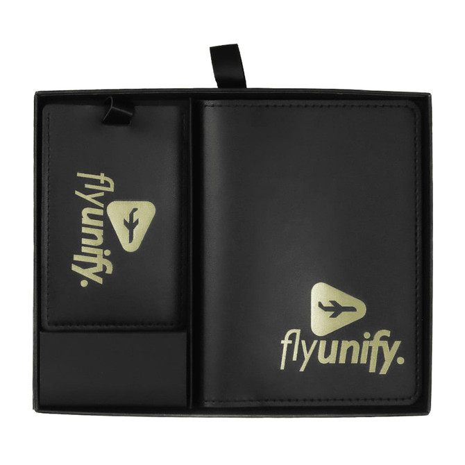 A black travel gift set featuring a luggage tag and a wallet, both with a logo. The items are organised within a sleek case.