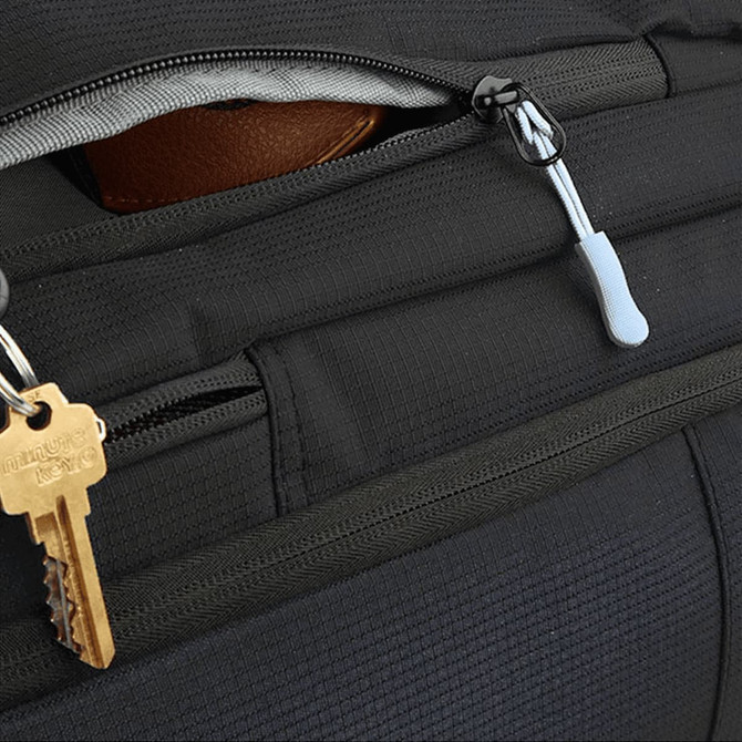 A close-up of a black backpack, featuring zippers and a keychain with a key attached.